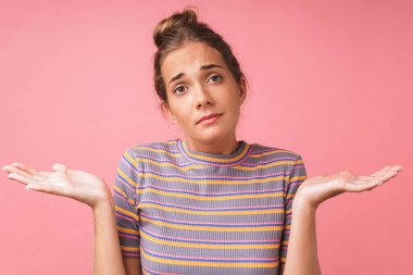 Kafası karışmış, sıradan kıyafetler giyen genç bir kadının yakın plan fotoğrafı.