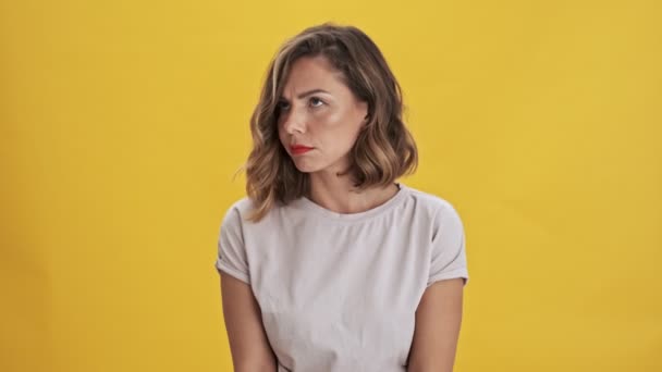 红唇的年轻女子悲喜交加 对黄色的背景感到厌烦 沮丧和烦恼 — 图库视频影像