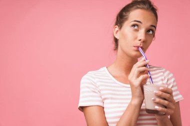 Fotoğrafta, gülümseyen ve çikolata içen muhteşem genç bir kadın görülüyor.