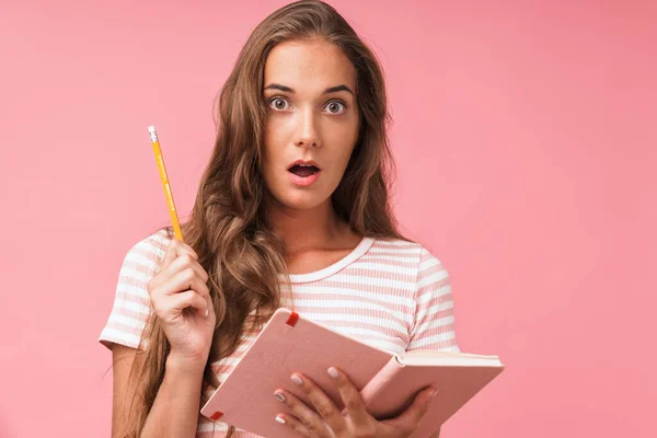 Image closeup of beautiful surprised woman wearing striped t-shirt looking at camera while holding diary and pencil — Stock Photo, Image