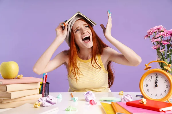 Foto van nerveuze student meisje met oefenboek op haar hoofd — Stockfoto