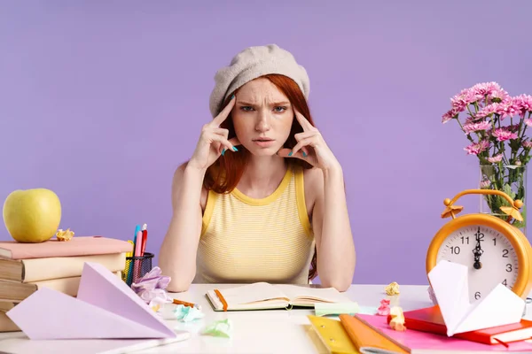 Foto van verward student meisje aanraken van haar tempels tijdens het doen — Stockfoto