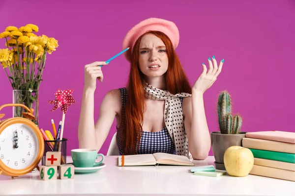 Afbeelding van puzzelde tiener meisje studeren met oefenboeken terwijl — Stockfoto