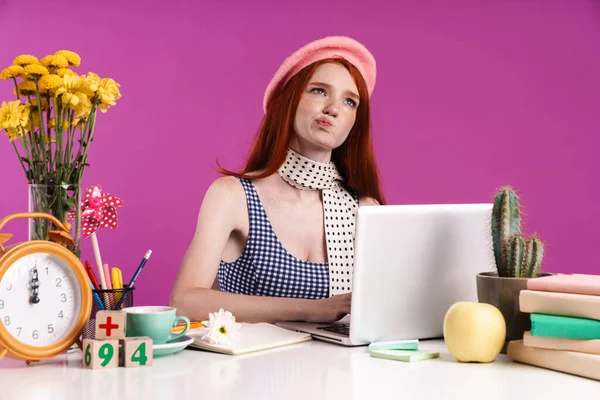 Image d'une adolescente réfléchie étudiant sur un ordinateur portable assis au bureau — Photo