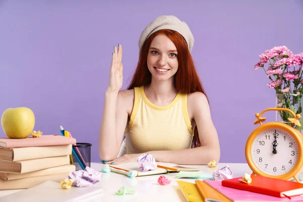 Photo de fille étudiante rousse levant la main alors qu'elle était assise au bureau sur la leçon — Photo