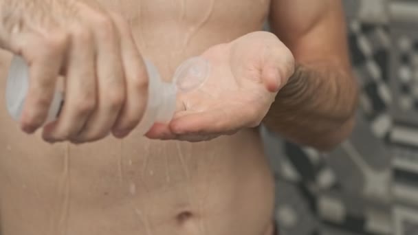 看到年轻的裸体男子在手上放洗发水 一边洗头一边洗澡 — 图库视频影像