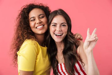 Çok uluslu esmer kızların birlikte kameraya gülümsemesi.