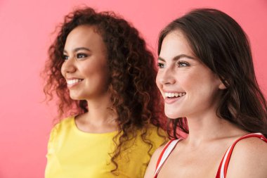 Çokuluslu tatmin olmuş, gülümseyen ve boşluğa bakan kızlar.