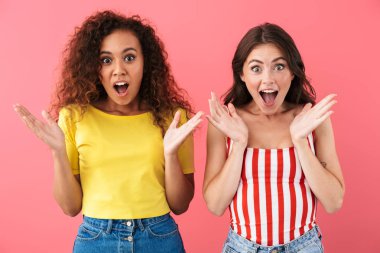 Çok uluslu neşeli kızların şaşkınlıkla el ele tutuşup el kaldırması.