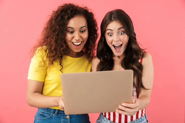 Изображение изумленных многонациональных девушек, радующихся и держащих ноутбук — стоковое фото