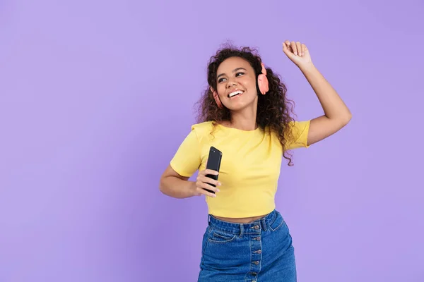 Imagen de una mujer afroamericana alegre escuchando música con auriculares —  Fotos de Stock