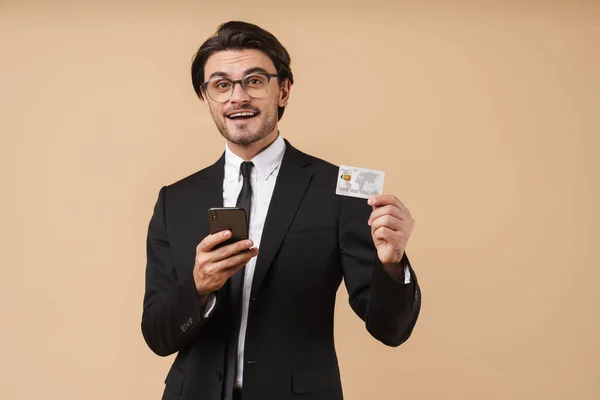 Wizerunek przystojnego biznesmena trzymającego telefon komórkowy i kartę kredytową — Zdjęcie stockowe