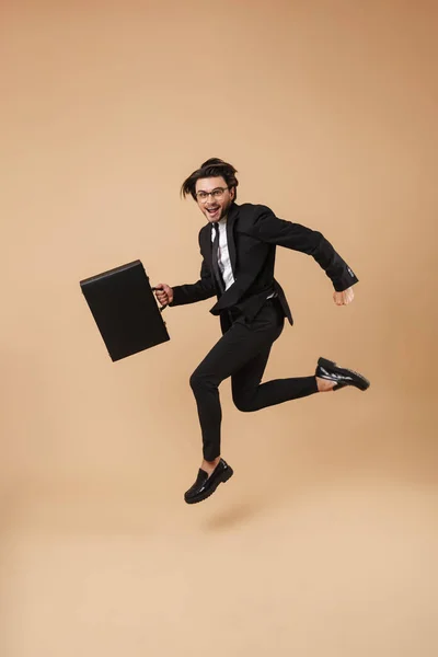 Full length image of caucasian businessman in suit running with — ストック写真
