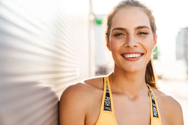 Imagen de una mujer hermosa en ropa deportiva sonriendo y caminando al aire libre — Foto de Stock