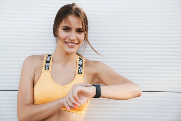 Imagen de mujer femenina de pie sobre la pared blanca al aire libre con w — Foto de Stock