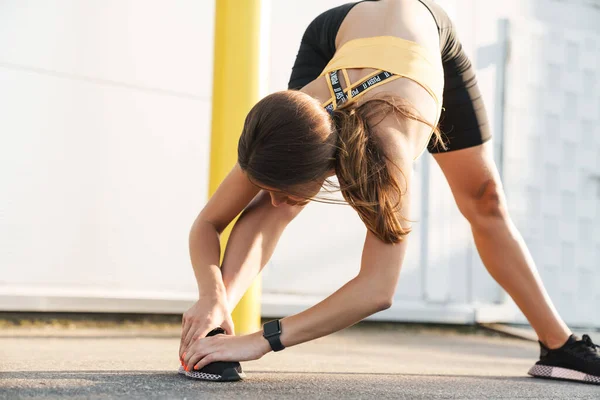 Beeld van atletische vrouw in sportkleding doet workout buiten — Stockfoto