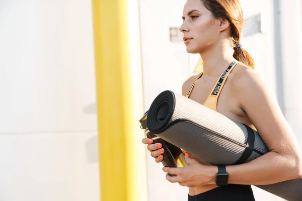 Image de la femme active marchant avec tapis de yoga et bouteille d'eau — Photo