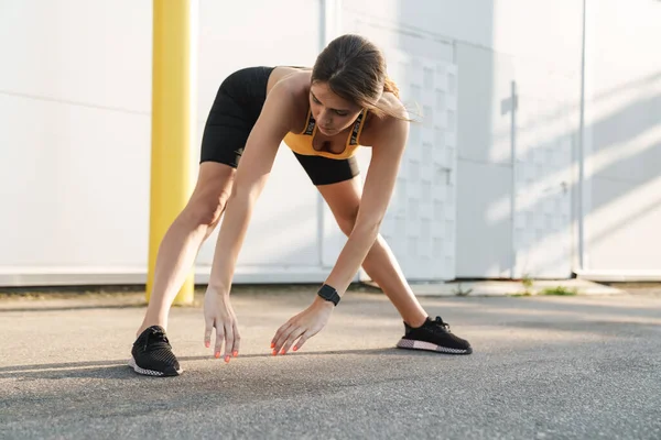 Image de femme énergique en vêtements de sport faisant de l'exercice à l'extérieur — Photo