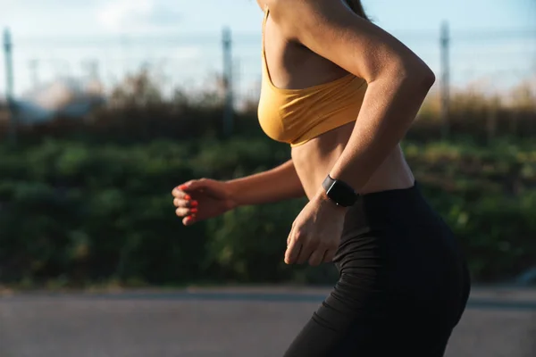 Imagen recortada primer plano de la mujer delgada en ropa deportiva corriendo outdoo —  Fotos de Stock