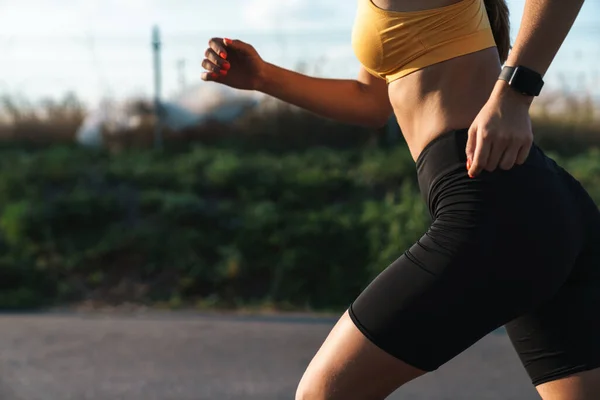 Cropped image strong of young woman in sportswear running outdoo — Stock Photo, Image