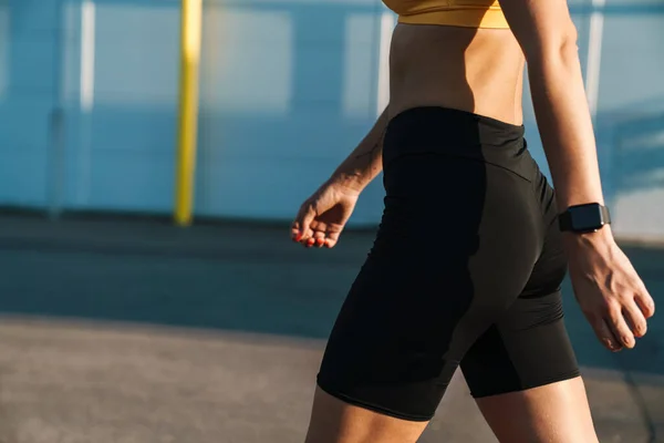 Ritagliato immagine primo piano di runner donna in abbigliamento sportivo a piedi outd — Foto Stock