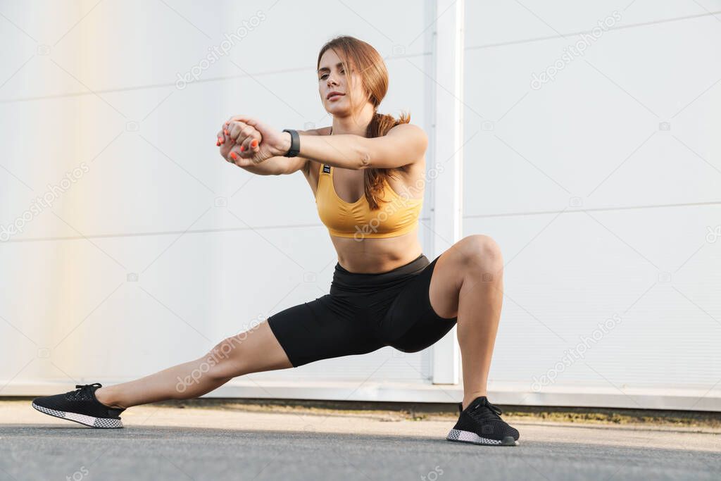 Image of slim woman in sportswear doing workout outdoors