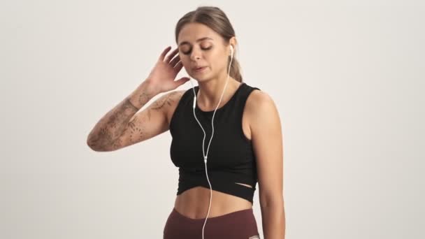 Sportig Kvinna Träningsoverall Lyssnar Musik Med Trådbundna Hörlurar Isolerade Över — Stockvideo