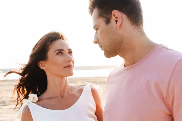 Schönes junges Paar in Sommerkleidung steht am Strand — Stockfoto