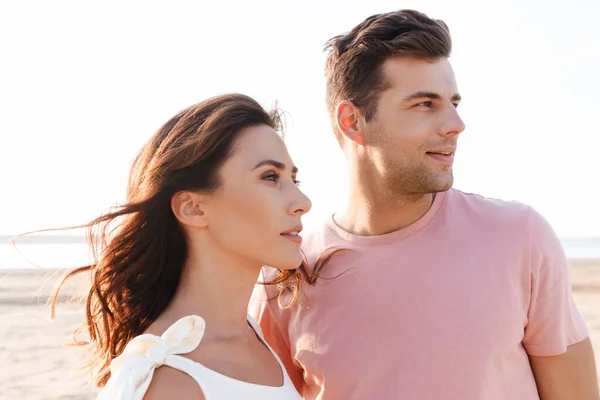 Schönes junges Paar in Sommerkleidung steht am Strand — Stockfoto