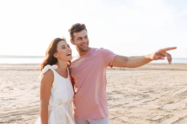 Schönes junges Paar in Sommerkleidung steht am Strand — Stockfoto