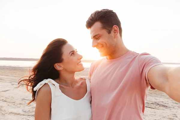 Beautiful young couple wearing summer clothing standing at the beach — Stock Photo, Image