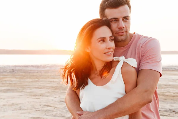 Krásný mladý pár na sobě letní oblečení stojící na pláži — Stock fotografie