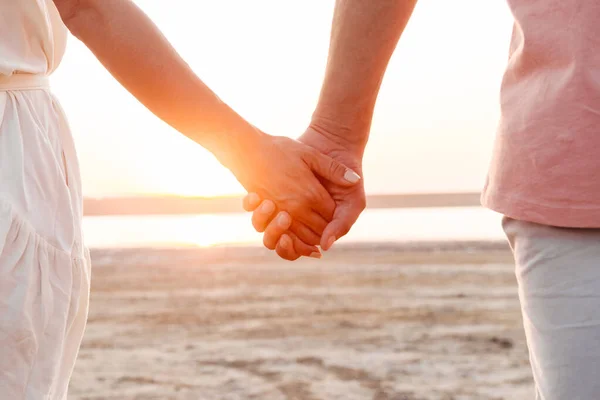 Κοντινό πλάνο ζευγαριού που κρατιέται χέρι-χέρι στην παραλία. — Φωτογραφία Αρχείου