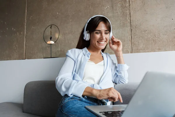 Frau zu Hause hört Musik mit Kopfhörern — Stockfoto