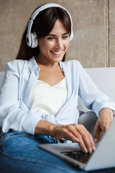 Woman indoors at home listening music with headphones — Stock Photo, Image