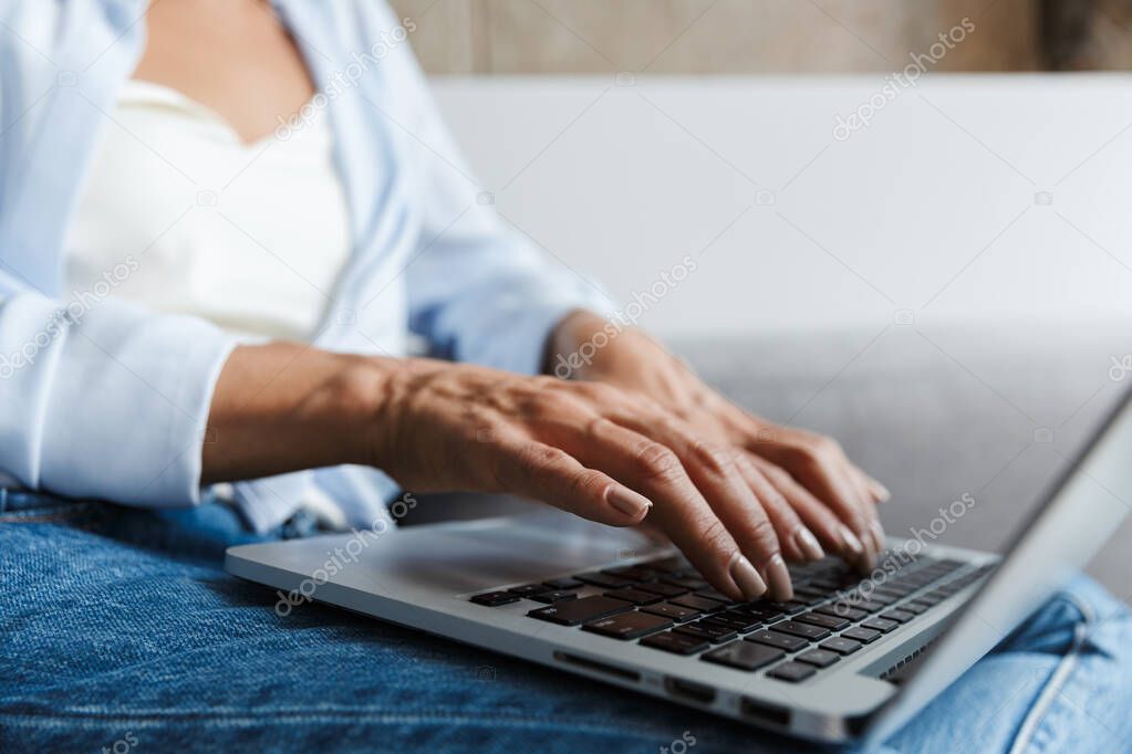 Woman indoors at home using laptop computer in livingroom.