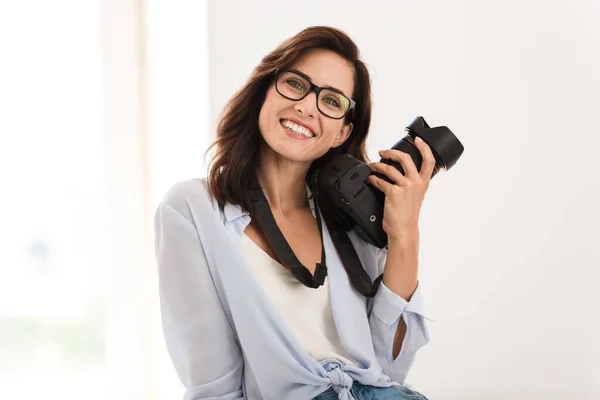 Optimismo joven fotógrafo mujer en la oficina celebración de la cámara . —  Fotos de Stock