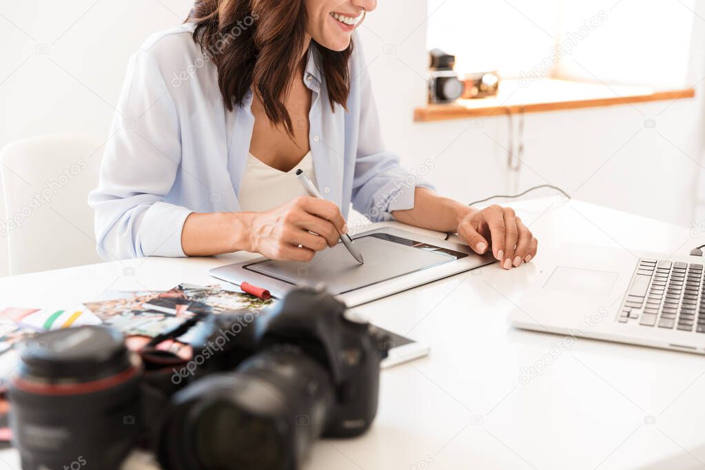 Beautiful young woman photographer working at her office