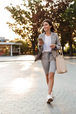 Cep telefonu kullanan çekici, şık bir genç kız.