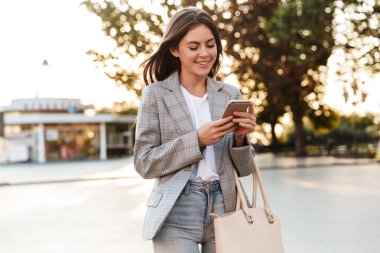 Cep telefonu kullanan çekici, şık bir genç kız.