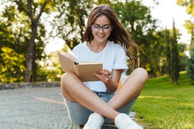 Genç kız okuma bir kitap gülümseyen