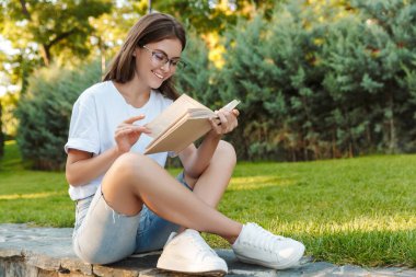 Genç kız okuma bir kitap gülümseyen
