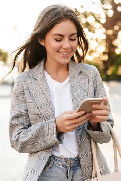 Aantrekkelijk stijlvol jong meisje met behulp van mobiele telefoon — Stockfoto