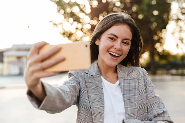 Jovem senhora de negócios andando pela rua tirar selfie por telefone móvel . — Fotografia de Stock