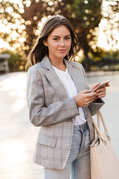 Aantrekkelijk stijlvol jong meisje met behulp van mobiele telefoon — Stockfoto