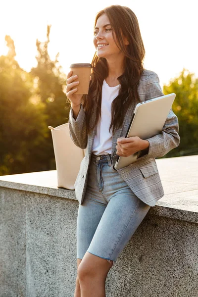 Mutlu genç iş kadını elinde dizüstü bilgisayarla kahve içiyor.. — Stok fotoğraf