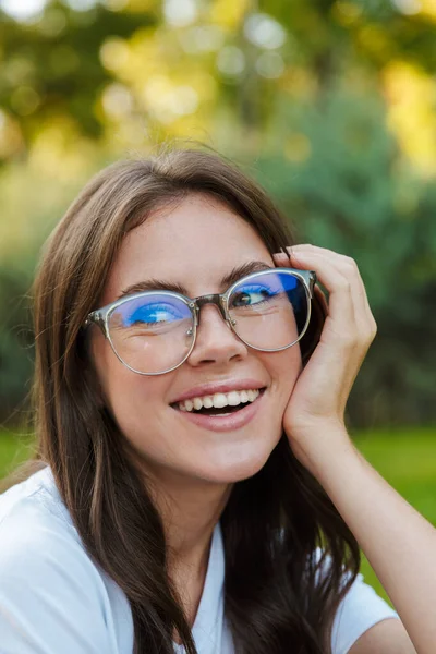 Close-up van een glimlachend mooi meisje zitten in het park — Stockfoto