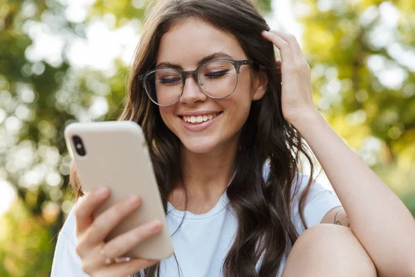 Dame buiten in natuurpark met mobiele telefoon. — Stockfoto