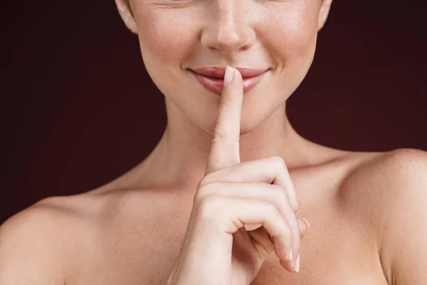 Imagen recortada de una mujer feliz sin camisa sosteniendo el dedo en su labio — Foto de Stock