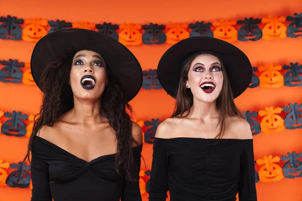 Imagen de mujeres brujas bonitas en traje de halloween negro buscando u —  Fotos de Stock